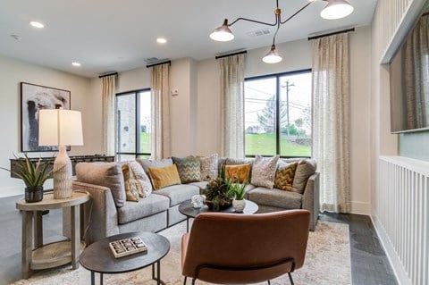 a living room with couches and chairs and a large window